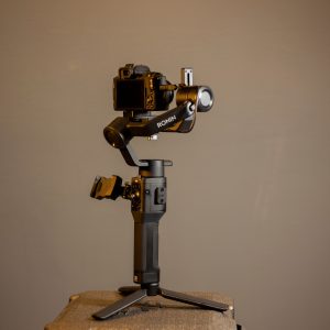 Studio shot of a DJI Ronin stabilizer holding a camera on a tripod. Perfect for videography needs.