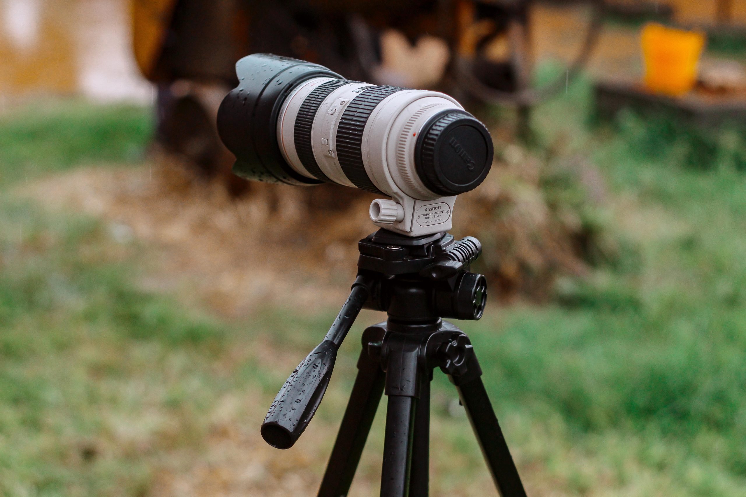 pexels photo 13633968 13633968 Close-up shot of a camera with zoom lens mounted on a tripod in a natural outdoor setting.