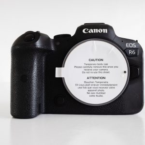 Close-up of a Canon EOS R6 camera body showcasing brand and design.
