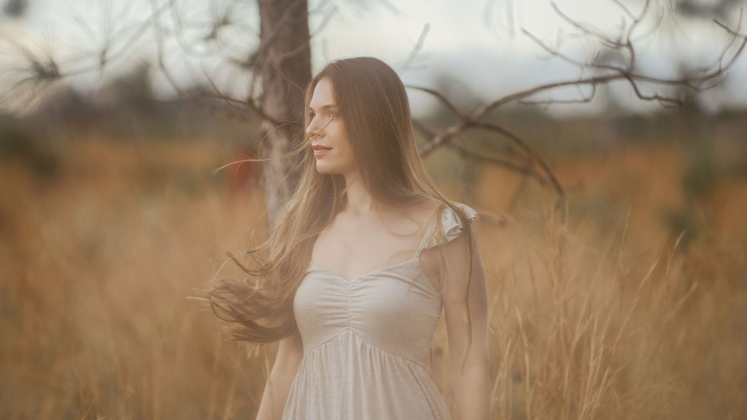πΈ Turning Ordinary Moments into Extraordinary Photographs A serene portrait of a woman standing in a rural field, embracing nature.