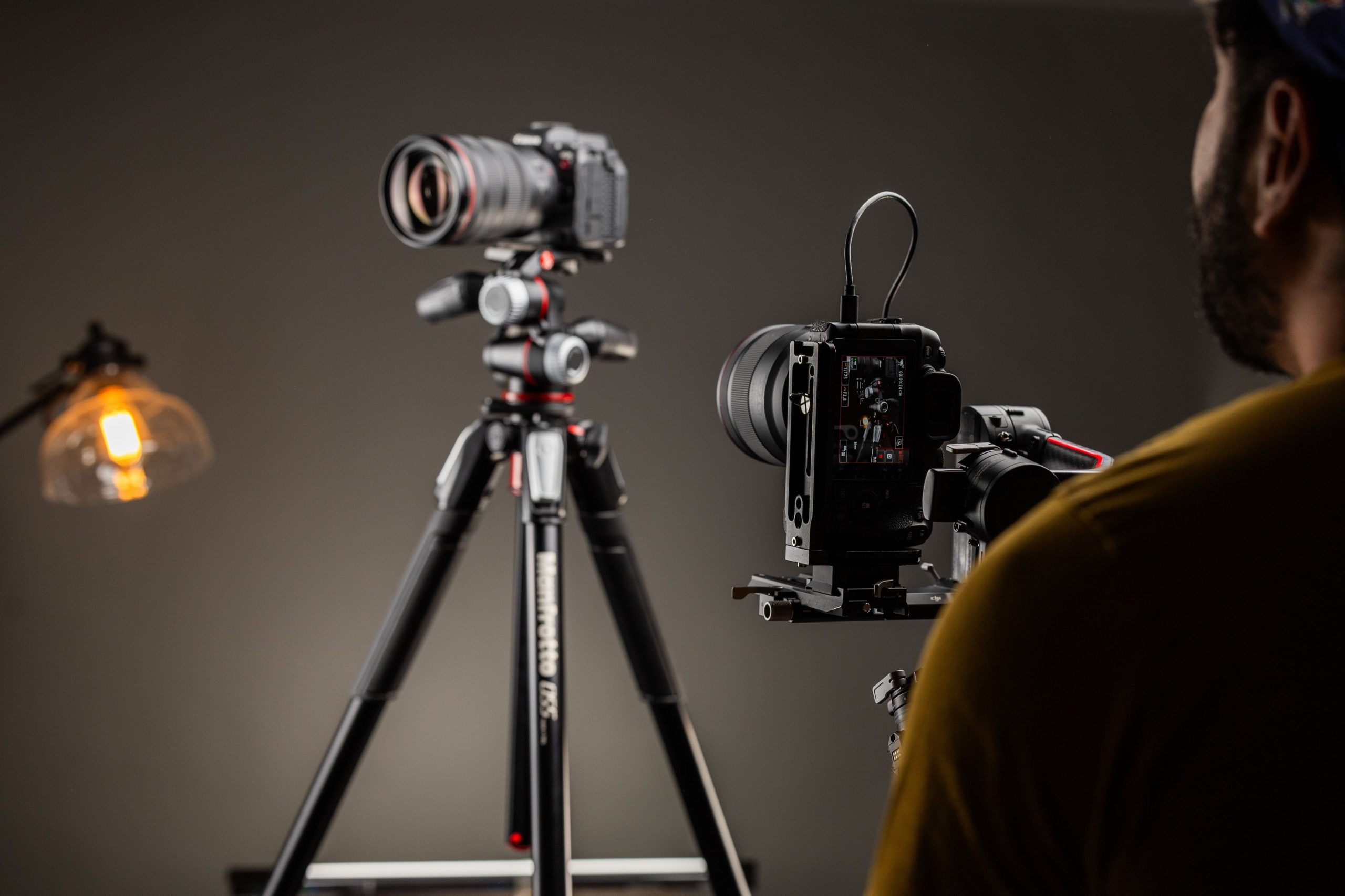 pexels photo 20325293 20325293 Photographer adjusting Canon camera on tripod in studio lighting setup.