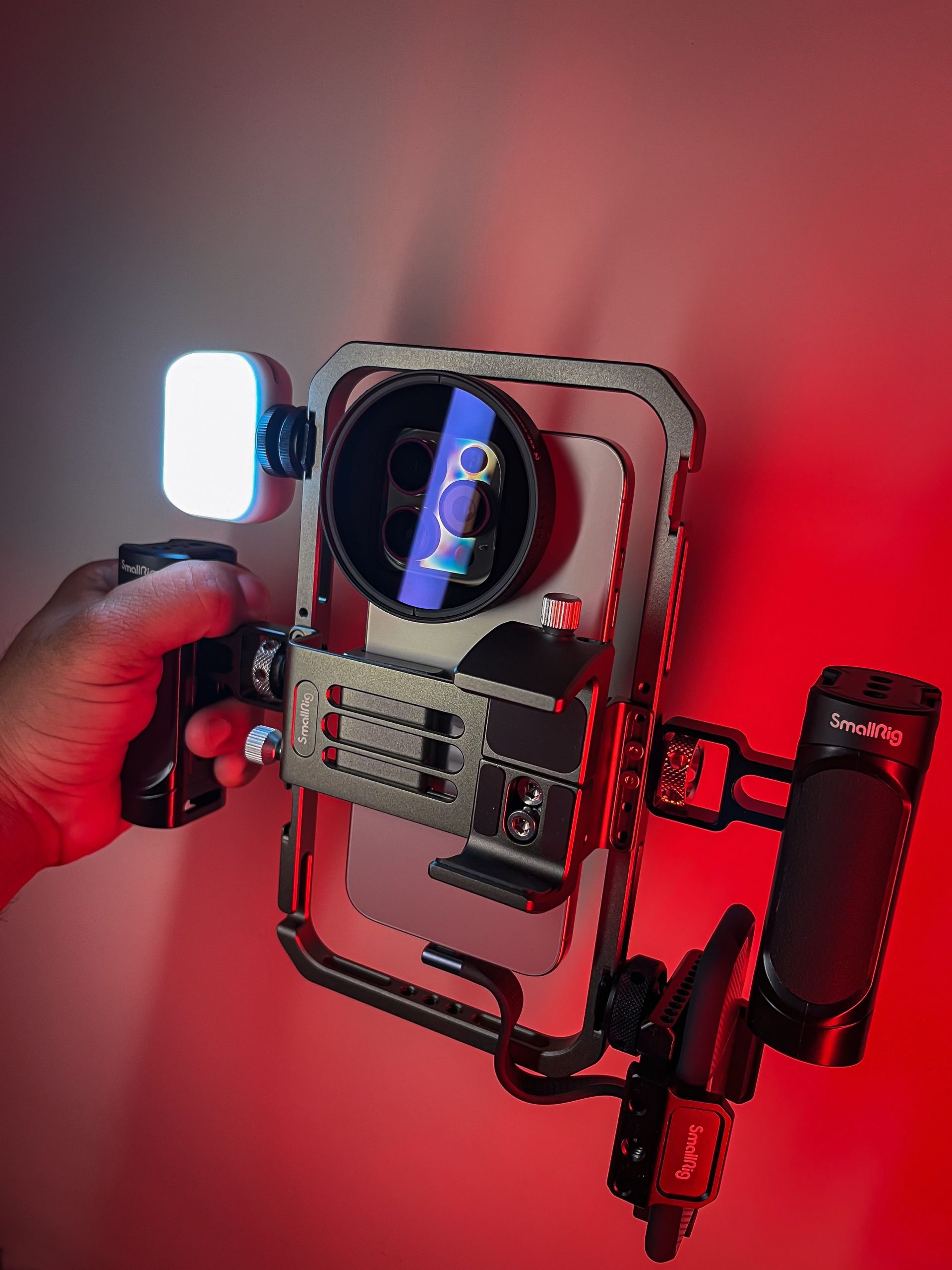 pexels photo 22447773 22447773 Close-up of a camera rig with LED light in a red-lit environment, capturing vibrant colors.