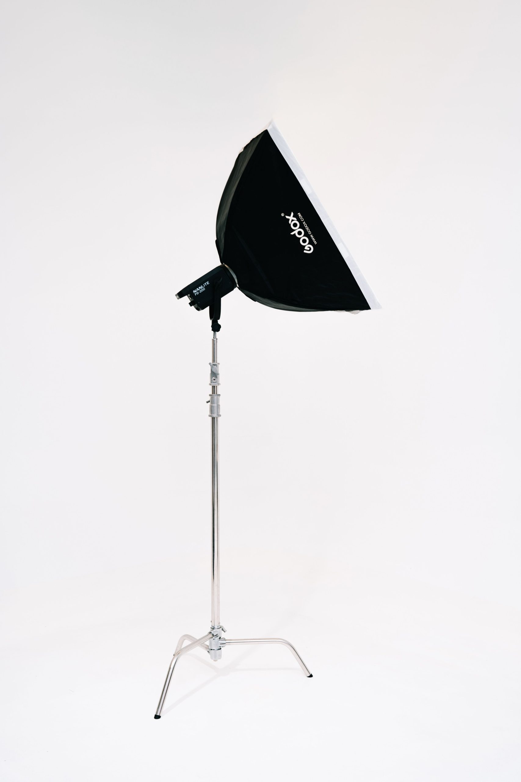 pexels photo 28772530 28772530 Black softbox on a silver light stand isolated against a white background.