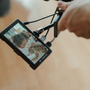 A camera monitor reveals a close-up shot of a child during filming, emphasizing creative processes.